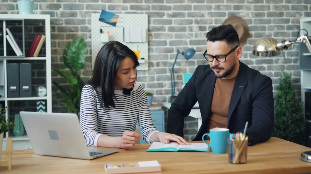 PowerPlay Franchise Consulting - Placement Data 1 executive man and woman sitting on a desk discussing franchise opportunities for professionals in career transition